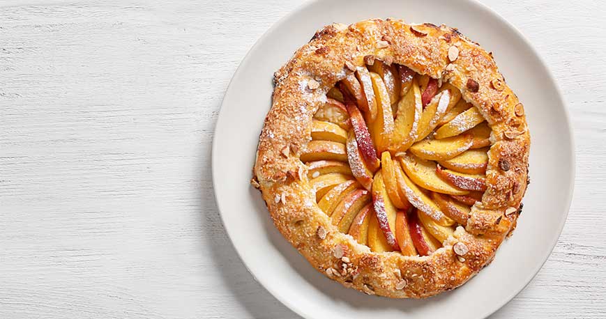 a peach galette on a wooden table